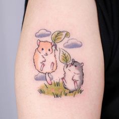 a hamster and gerbil tattoo on the left arm, with clouds in the background