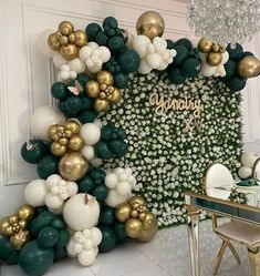 the balloon wall is decorated with gold, white and green balloons