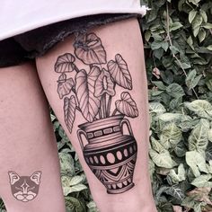 a woman's legs with tattoos on them and flowers in a vase tattoo design