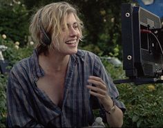 a woman sitting in front of a camera with a smile on her face while talking to someone