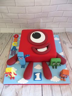 a birthday cake with an image of a red monster on the front and two blue monsters on the back