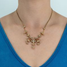 This beautiful necklace features a floral design, bead set with a total of seventy-eight (78) seed pearls. The necklace has charm/drop hook at the bottom and is finished with a rope chain with an overall length of 17 inches, including the 1.5 inch extension. Signed Birks. Elegant Antique Gold Necklace With 17 Jewels, Victorian Style Gold Beaded Necklace, Elegant Antique Gold Jewelry With Lobster Clasp, Elegant Antique Gold Flower Pendant Jewelry, Elegant Antique Gold Pendant Necklace, Elegant Flower Pendant Necklace With Lobster Clasp, Elegant Beaded Flower Pendant Jewelry, Heirloom Formal Necklace With Flower Pendant, Heirloom Style Formal Necklace With Flower Pendant