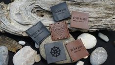 four leather coasters with the words you & me on them sitting on some rocks