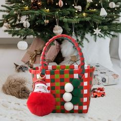 a cat laying on the floor next to a christmas tree with presents in front of it