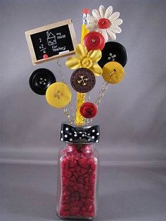 a vase with buttons and other items in it