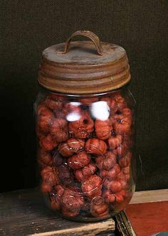 a glass jar filled with nuts sitting on top of a wooden table next to a book