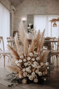 an arrangement of flowers is on the floor in front of a dining room table with chairs