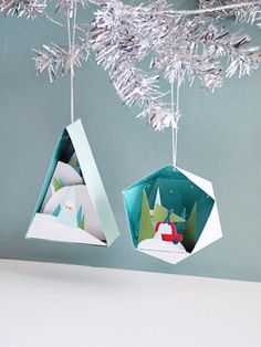 two origami ornaments hanging from a christmas tree