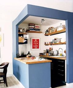 a kitchen with blue walls and open shelves