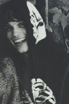 a black and white photo of a woman wearing a hoodie smiling at the camera