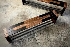 two wooden benches sitting on top of a cement floor