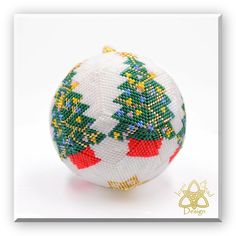 a white ornament with green and red christmas trees on it's sides