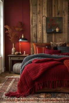 a bedroom with red walls and wood paneling, bedding is made up in various colors