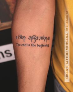 a person with a tattoo on their arm that says, the end is the beginning