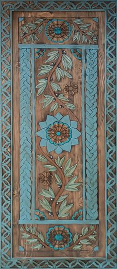 an intricately designed wooden panel with flowers and leaves on it's sides, in blue