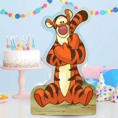 a winnie the pooh birthday cake topper with candles in the background and decorations around it