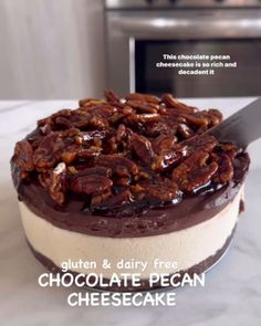 a chocolate pecan cheesecake on a counter top with a knife in the middle