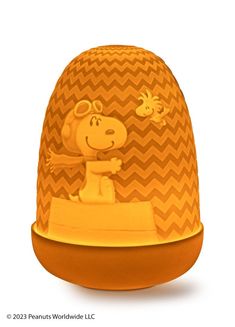 an orange and yellow hat with a cartoon character on it's face, sitting in front of a white background