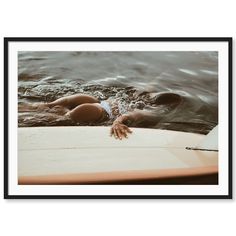 a woman laying on top of a surfboard in the water