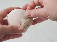 two hands are holding a small stuffed animal