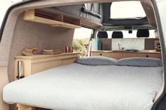 the interior of a camper van with its bed pulled out