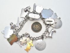 Fine Jewelry - This is a vintage sterling silver link charm bracelet with 18 charms. The bracelet is 7" long, .25" wide and hallmarked Sterling on the clasp. Charms vary from .5" to 1" long. Total weight is 50.1 grams. Charms are: Maltese cross, hallmarked Sterling, signed LGB Enamel Cumberland Caverns, not sterling Girl Scout, marked R Sterling Goblet, not sterling Airplane, hallmarked and signed P & B Sterling Enamel Georgia, hallmarked Sterling Baby Booty, engraved Walked 14 months Capitol, h Bracelet With Charms, Maltese Cross, Girl Scout, Sterling Silver Bracelet, Baby Booties, Maltese, Vintage Sterling Silver, Sterling Silver Bracelets, Vintage Silver