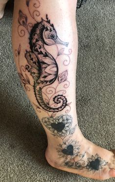 a close up of a person's foot with a sea horse tattoo on it