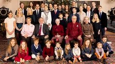 a large group of people are posing for a photo in front of a christmas tree