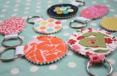 several different types of keychains on a blue table with white polka dotes