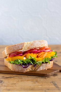 a cut in half sandwich sitting on top of a wooden cutting board