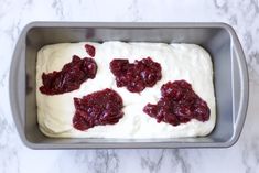 a pan filled with white frosting and cranberry toppings on top of it