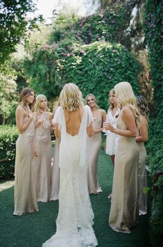 a group of women standing next to each other on top of a lush green field