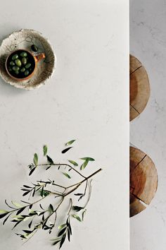 a bowl with some green beans in it on top of a table next to two wooden stools