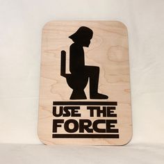 a wooden sign that says use the force with a silhouette of a person sitting on a toilet