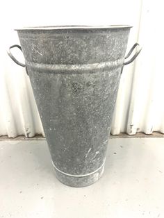 a metal bucket sitting on top of a white counter next to a wall and window