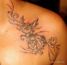 the back of a woman's shoulder with tattoos on it