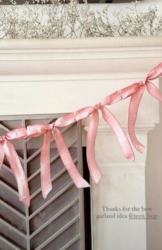 a pink ribbon hanging from a fireplace mantel