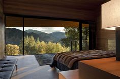 a bedroom with a large window and mountain view in the backgroung area