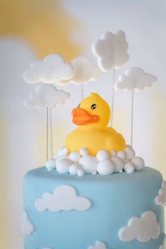 a blue cake with white clouds and a rubber duck