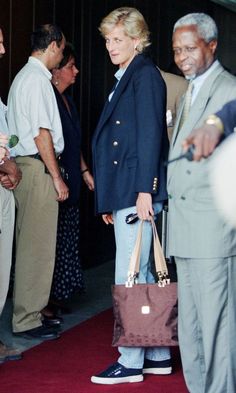 a woman holding a brown bag standing next to two men