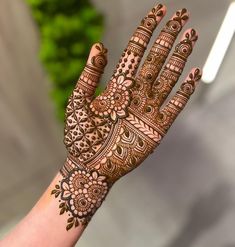 a woman's hand with henna tattoos on it