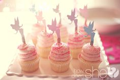 there are cupcakes with pink frosting and fairy wands on the top