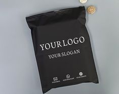 a black bag with the words yourlogo on it next to two gold coins