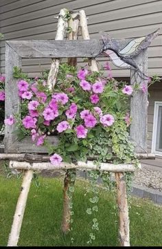 an old wooden chair with flowers growing out of it's back legs in front of a house