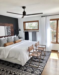 an instagram photo of a bedroom with white bedding and black accents