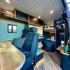 the interior of an rv with wood flooring and blue upholstered seating area