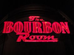 the bourbon room sign lit up at night with red neons on it's side