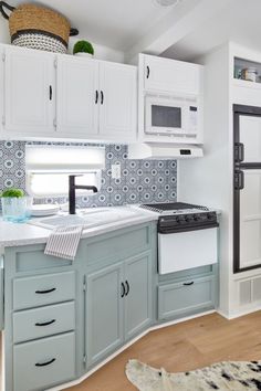 a kitchen with white cabinets and blue counter tops, along with a rug on the floor