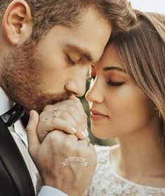 a man and woman holding each other close to their foreheads as they look at each other