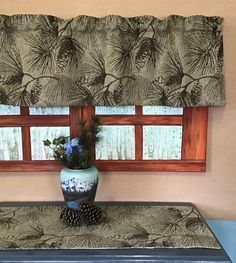 a blue and white vase sitting on top of a wooden table next to a window